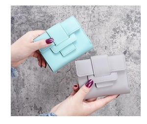 Detail of mint green and gray tri-fold short wallets in textured PU leather