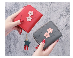 Close-up of PU leather wallets with floral embroidery and tassel star charm details