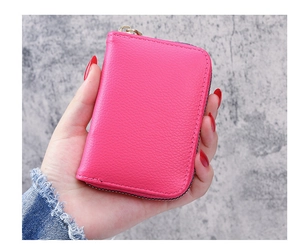 Detailed texture of rose red litchi grain leather card holder with secure metal zipper