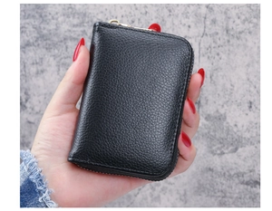 Close-up of black lychee grain card holder with gold zipper held by a model