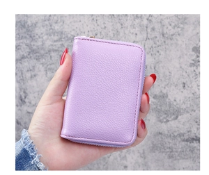 Close-up of lilac litchi grain leather card holder with gold zipper and hand stitching