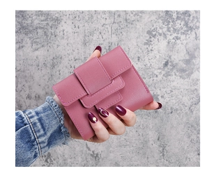 Close-up of compact tri-fold pink PU leather wallet for women with snap closure