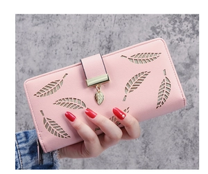 Close-up of light pink long wallet with hollow leaf design and gold leaf pendant