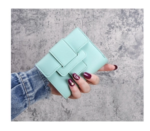 Close-up of mint green tri-fold wallet with elegant buckle and textured leather detail