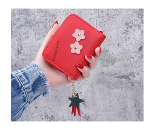 Detail of red PU leather wallet with flower appliqués, star charm and fringe tassel
