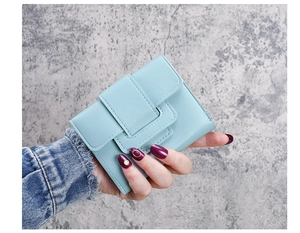 Close-up of light blue pebbled leather wallet featuring double square buckle decoration
