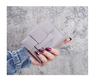 Detail of grey-purple lychee pattern leather wallet with layered buckle strap closure