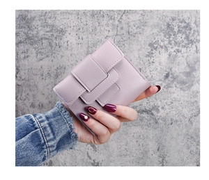 Detail of light purple short wallet featuring textured leather and fine edge stitching