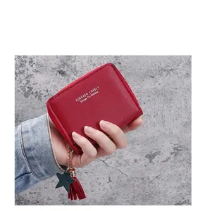 Close-up of red PU leather wallet with gold zipper and green star tassel detail