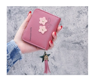 Close-up of pink PU leather coin purse with flower patches and star tassel charm