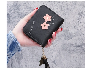 Close-up of black PU leather floral wallet with tassel charm and star pendant detail