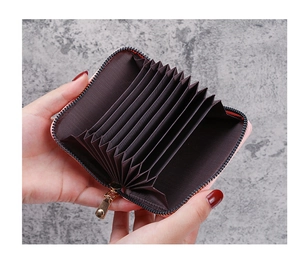 Detail of pink accordion card holder showing multiple internal slots and metal zipper