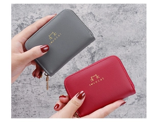 Close-up of red and grey faux leather wallets featuring gold cat print and metal zippers