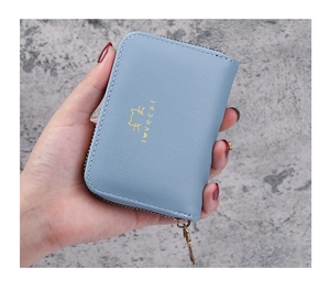 Close-up of light blue leather card holder with gold cat print and zipper closure