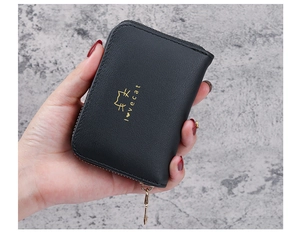 Close-up of black leather accordion card holder featuring a gold cat logo and zipper detail
