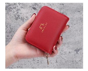 Close-up of red leather cat card holder with gold lovecat logo and zipper detail