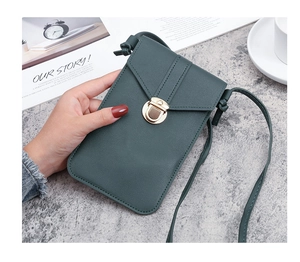 Detail of dark green PU leather phone bag with V-shaped flap and gold clasp