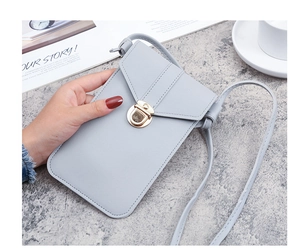 Detail of light blue PU leather phone bag with gold clasp on marble background
