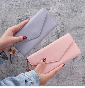 Details von rosa und lila Kunstleder-Geldbörsen mit Herzanhängern und Quasten