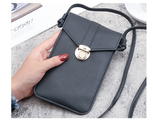 Detail of black litchi texture phone crossbody bag with a golden arc clasp lock