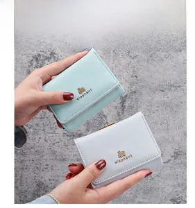 Close-up of soft PU leather wallets in blue and grey featuring golden elephant icons