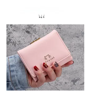 Detailed view of light pink PU leather wallet with gold cat ornament and metal clasp closure