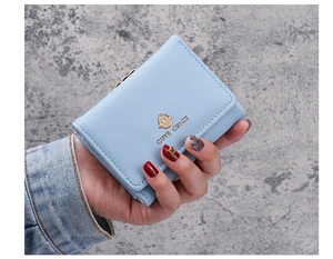 Close-up of a light blue tri-fold PU leather wallet with a cute chick metal logo