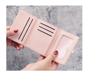 Detailed interior of a pink three-fold leather wallet showing card slots and ID window