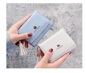 Detail of short tri-fold wallets with cute metal animal icons and fringe tassels