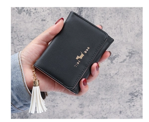 Detail of a black leather trifold wallet featuring a gold dog logo and white tassel charm