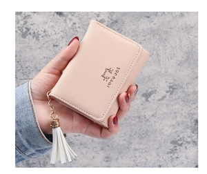 Close-up of pink tri-fold faux leather wallet featuring a cat logo and white tassel