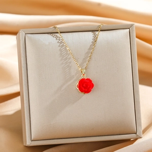 Elegante Halskette aus Goldtitan mit 3D-roter Rose auf seidigem Hintergrund im Licht