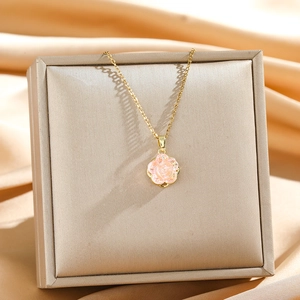 Elegante goldene Halskette mit rosa Rosenanhänger auf einem Seidendisplay für Schmuck