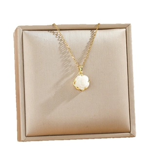 Elegante Halskette mit weißer Rose an Goldkette über einer luxuriösen Schmuckbox