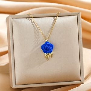 French style gold chain necklace with a blue velvet rose pendant and golden bow detail