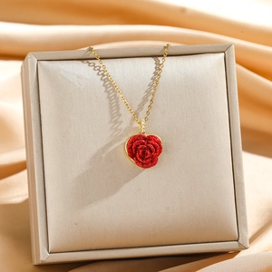 Gros plan du pendentif cœur rose rouge sur fond de velours champagne élégant