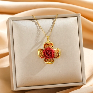 Collier fleur dorée élégant avec une rose rouge présenté sur un coffret en satin
