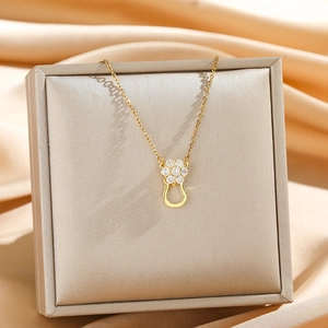 Exquisite goldene Hufeisen-Halskette mit Zirkonia-Blumenanhänger auf Schmuckbox