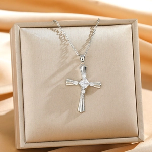 Detailed view of silver cross necklace with square zircon on a premium jewelry display