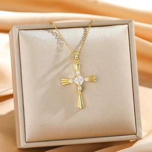 Golden snake cross necklace with clear zircon pendant on champagne silk background