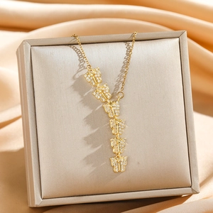 Elegant gold titanium butterfly tassel necklace with pavé zircons on display padding