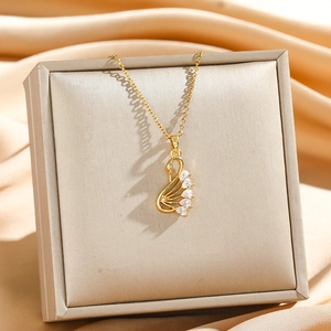 Collana con ciondolo a cigno dorato e cristalli a goccia su espositore in raso