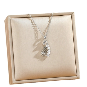 Collana con ciondolo a cigno in argento e pietre di zirconia su sfondo di velluto oro