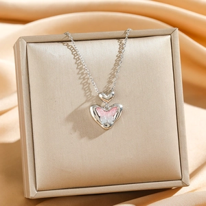 Elegant gradient pink butterfly and silver heart pendant necklace on silk backdrop