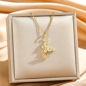 Collier doré avec pendentif double papillon et zircons sur support en satin de luxe