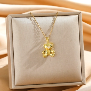 Elegant gold 3D teddy bear pendant necklace with heart gemstone on satin display