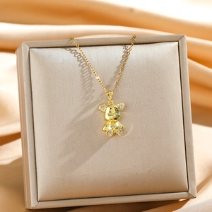 Luxurious gold bear pendant necklace with sparkling crystals on elegant silk background