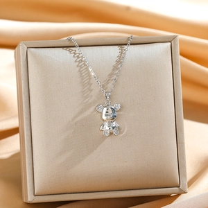 Detailed macro view of a silver bear pendant with sparkling zircon inlays on a jewelry box