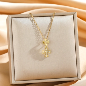 Elegant gold double-layered cross necklace with sparkling zircons on a satin backdrop