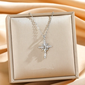 Elegant silver cross star pendant necklace with sparkling zircons on satin background